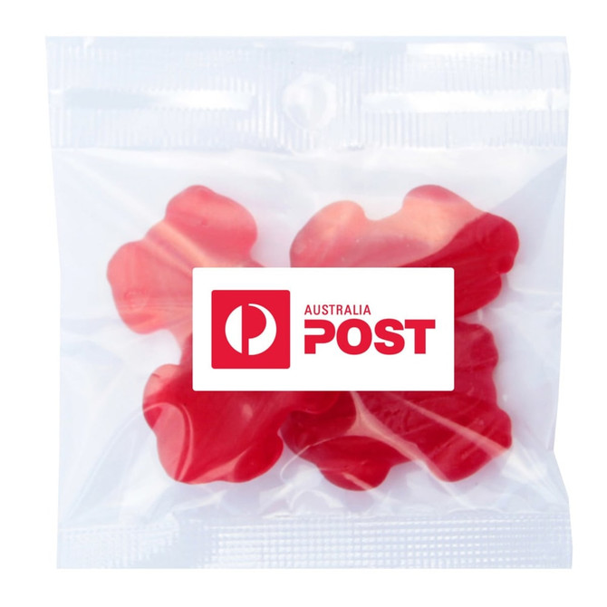 A clear bag containing red gummi lollies shaped like frogs. The bag has a logo.
