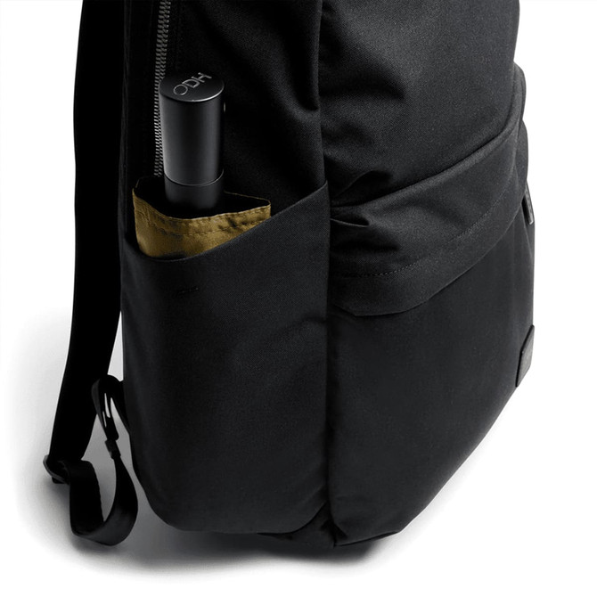 A black daypack with a drink bottle in the side pocket, featuring a simple and sleek design. A black daypack with a drink bottle in the side pocket, featuring a simple and sleek design.