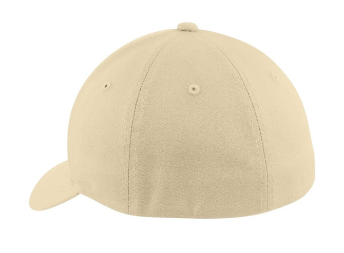A beige Flexfit cotton twill cap featuring a rounded crown and a curved brim, with a small logo on the back.