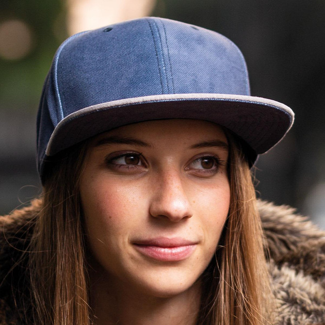 A woman wearing a blue cap with a contrasting brim, featuring a logo on the front.