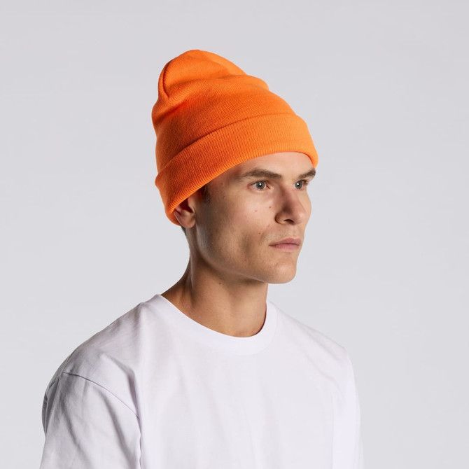 An orange beanie is worn by a person in a plain white t-shirt, facing to the side. The beanie features a logo.