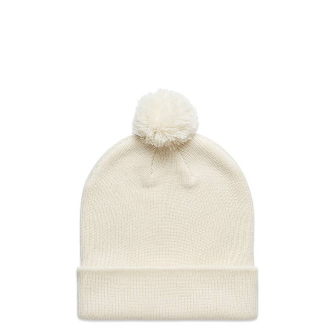 A cream-coloured beanie with a fluffy pom-pom on top, featuring a rolled cuff and a logo.