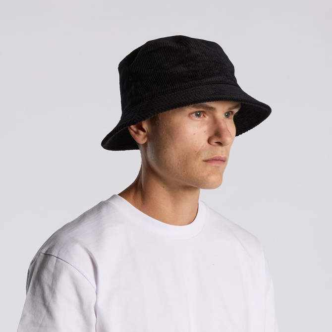 A black cord bucket hat worn by a person in a white t-shirt, featuring a simple, unadorned design.