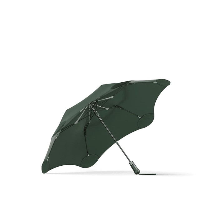 A green BLUNT Metro Umbrella with a distinctive shape and a metallic handle, featuring a logo on the canopy.