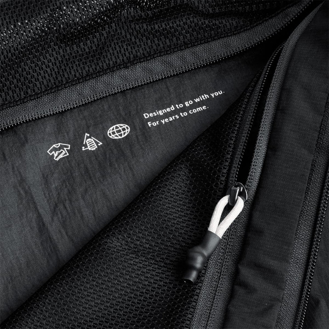 A black packing cube with a mesh panel and zip closure, featuring a subtle logo and design details.