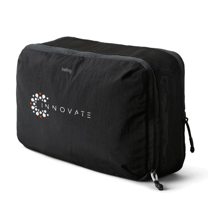 A black packing cube with a mesh side, featuring a logo. Designed for efficient organisation of belongings.