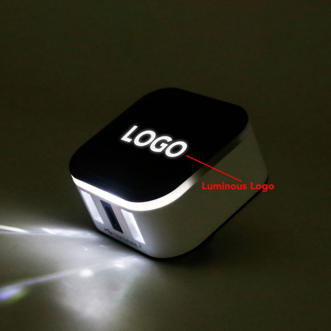 A Luminous Travel Adapter in black and white, featuring a glowing logo and multiple USB ports.