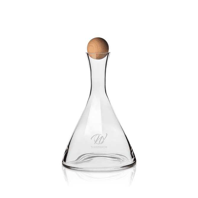 A glass wine decanter with a clear finish and a beechwood stopper, featuring a logo on its body.