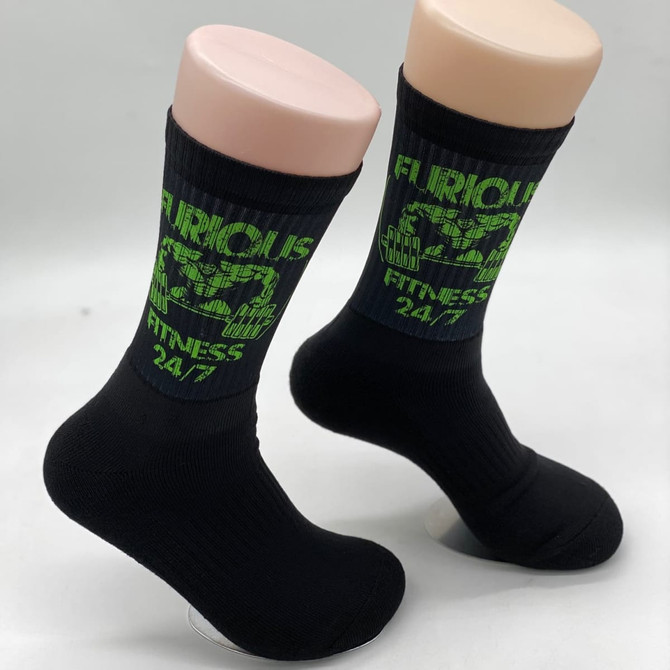 Black socks featuring a green design and branding on the upper part. The socks have a ribbed texture.