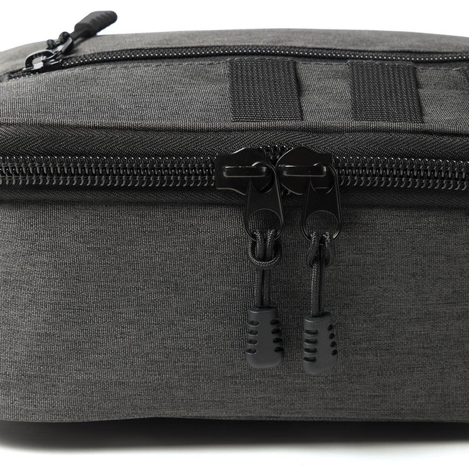 A cooler in dark grey fabric with a zippered closure and black pull tabs, featuring a logo.