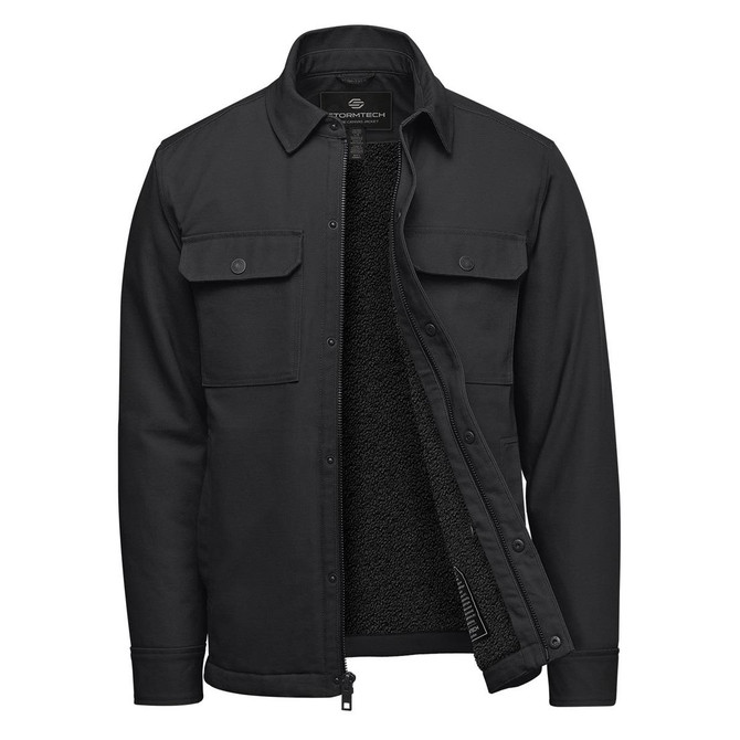A black men's jacket with a sherpa lining, featuring buttoned chest pockets and a zip front. It has a logo on the inside.