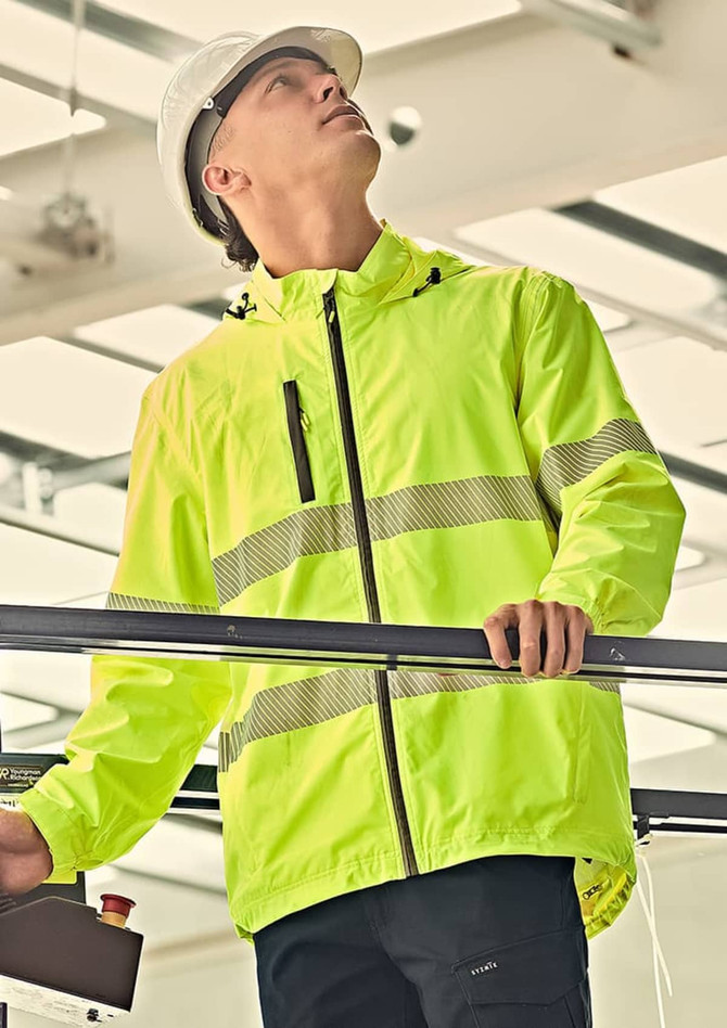 A bright yellow rain jacket with reflective stripes, worn by a person in a safety helmet, standing indoors.