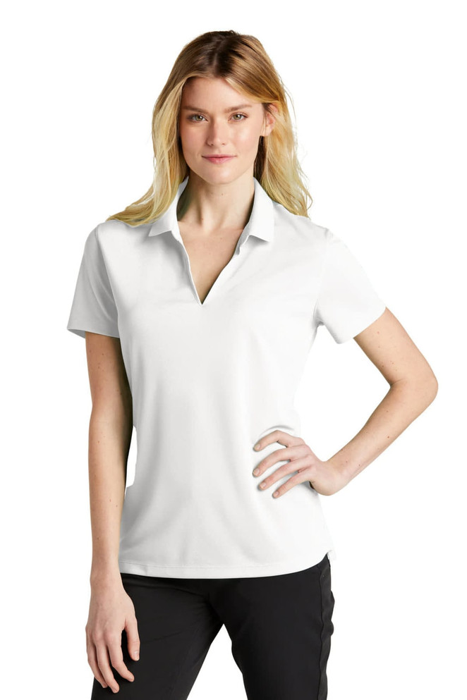 A white polo shirt featuring a collar and short sleeves, modelled by a woman with long blonde hair. It has a logo.