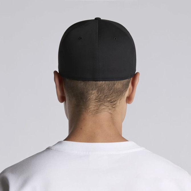 A black cap is worn backwards by a person with short hair, featuring a logo on the back.
