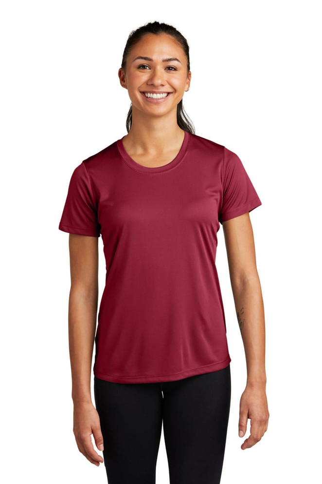 A woman wearing a burgundy Sport-Tek Ladies PosiCharge Competitor Tee, featuring a crew neck and short sleeves.