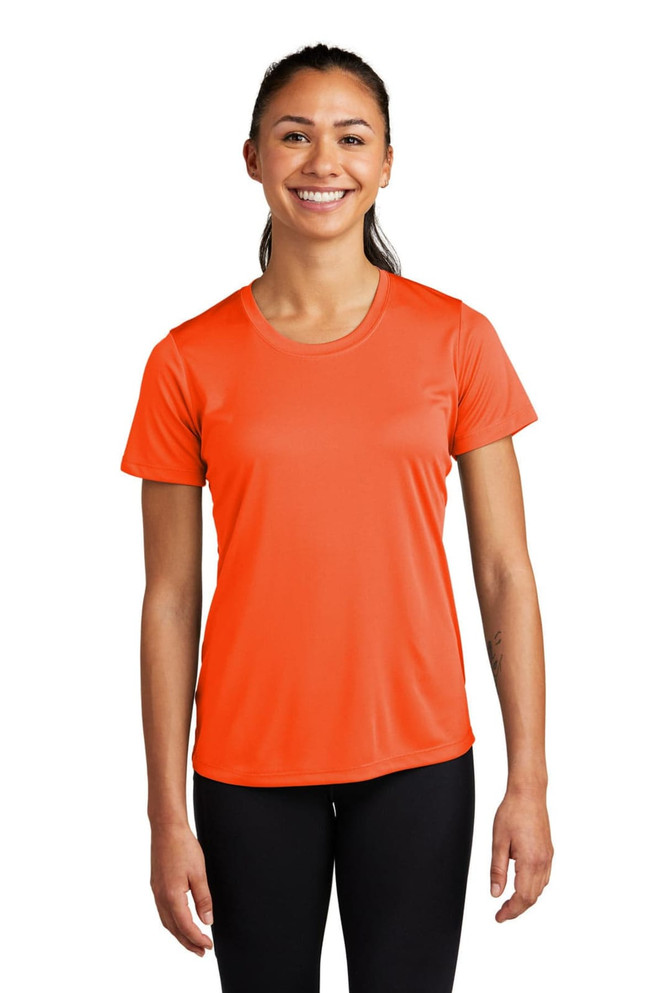 A woman is wearing an orange short-sleeved athletic t-shirt with a logo on the chest.