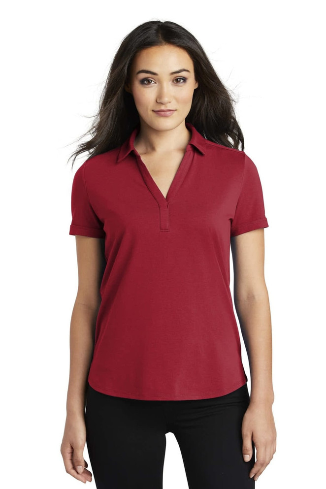 A red OGIO ladies polo shirt with a collar and short sleeves, featuring a logo on the chest.