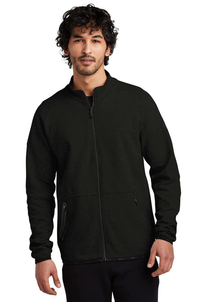 A black OGIO ENDURANCE Origin Jacket with a zip closure and side pockets, featuring a logo.