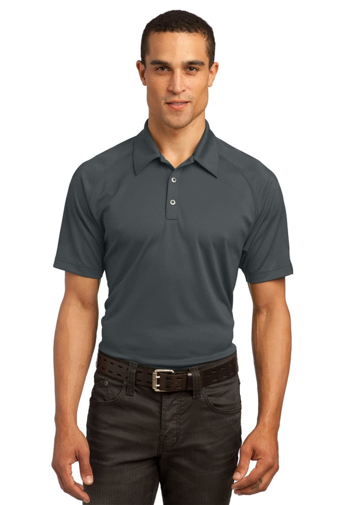 A male model wearing a grey OGIO Optic Polo shirt paired with dark trousers, featuring a subtle logo.