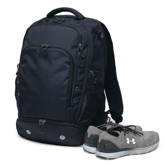 A navy backpack with multiple pockets, accompanied by a pair of grey sports shoes. The bag has a logo.