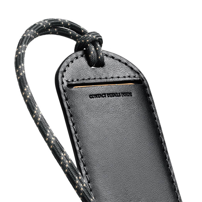 A black luggage tag with a textured surface and a patterned strap, featuring a branding logo.