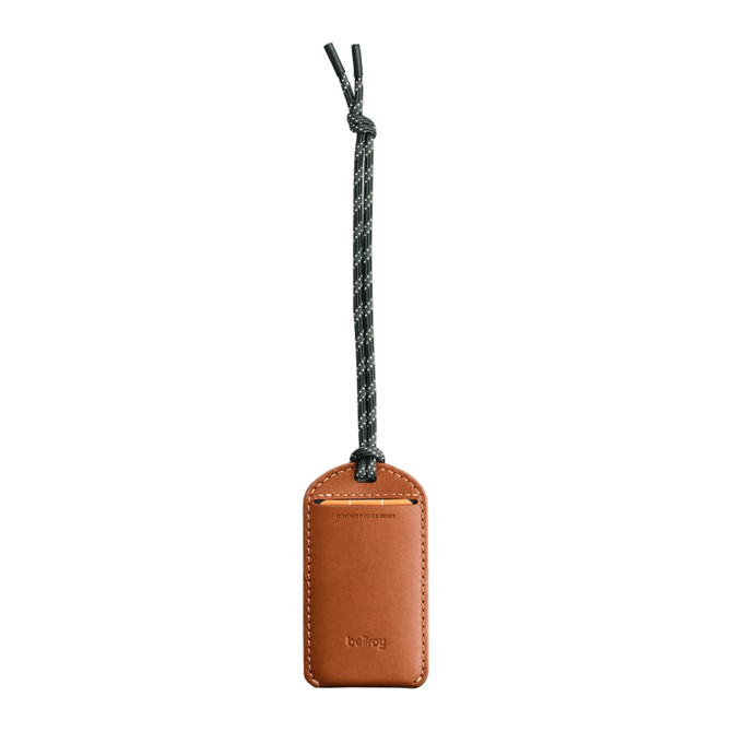 A brown leather luggage tag with a black and white braided attachment. It features a branding logo.