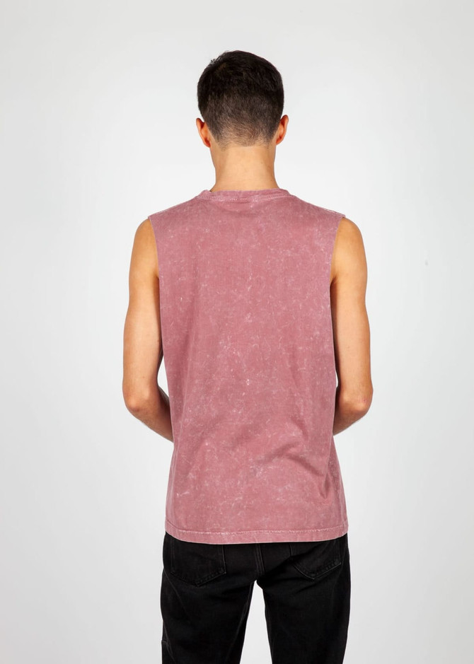 A men's stone wash tank in a muted pink hue, featuring a sleeveless design and a logo on the side.