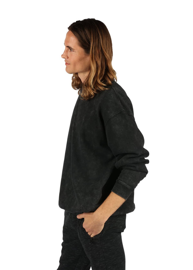 A unisex stone wash sweatshirt in black, displayed side view with a relaxed fit and long sleeves.