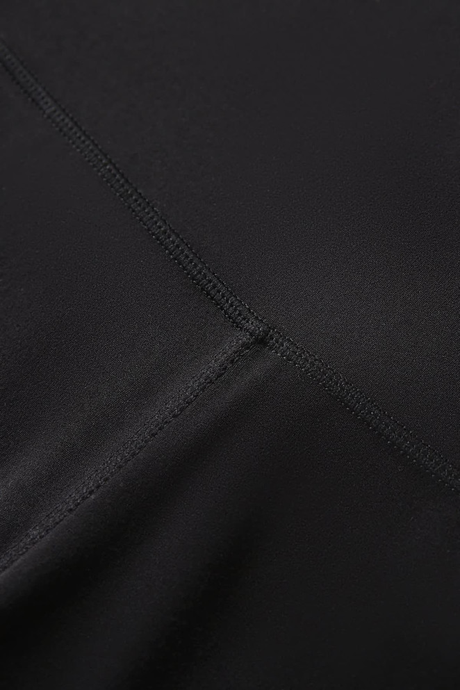 A close-up of black women's high rise full length leggings, featuring smooth fabric and stitching details.