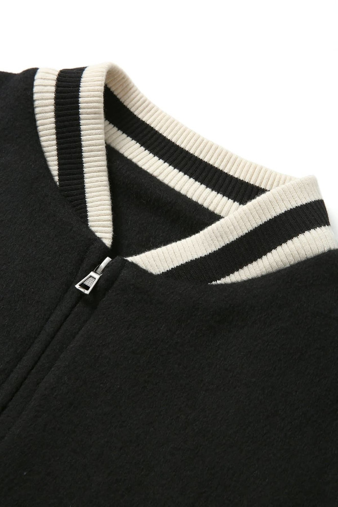 A black wool blend varsity jacket featuring a ribbed collar with black and cream stripes.