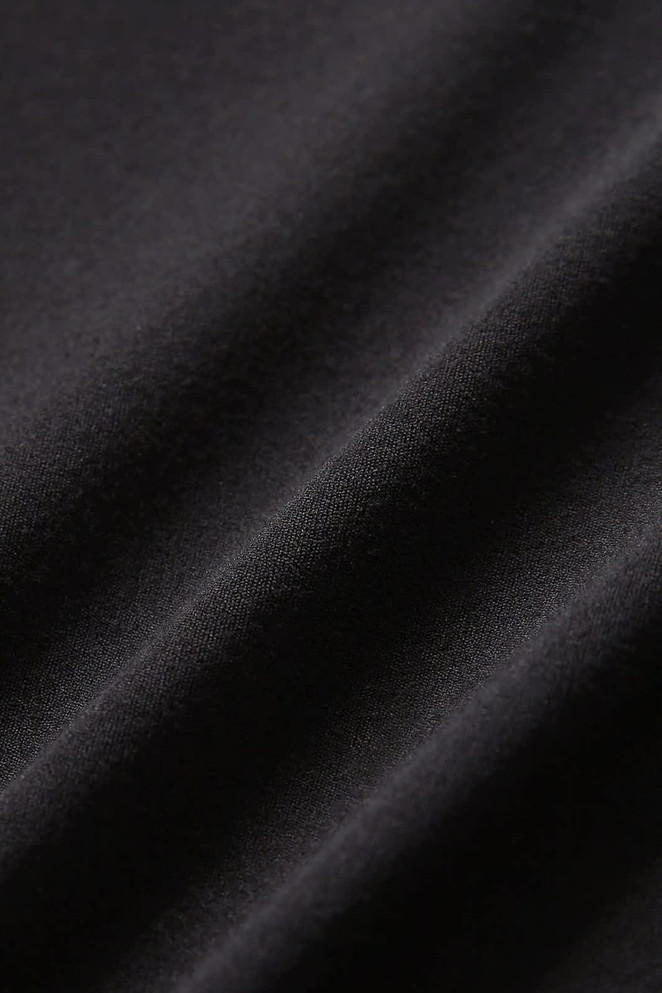 A close-up of black fabric featuring soft texture and subtle folds, suitable for high rise legging shorts.
