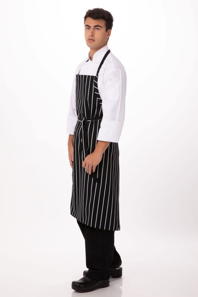 A black and white striped chef apron worn over a white shirt, featuring a logo and paired with black pants and shoes.