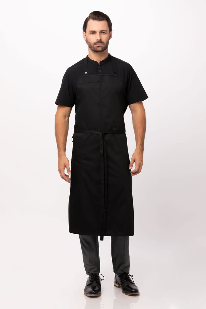 A black chef bib apron worn by a model, featuring a sleek design and a logo.