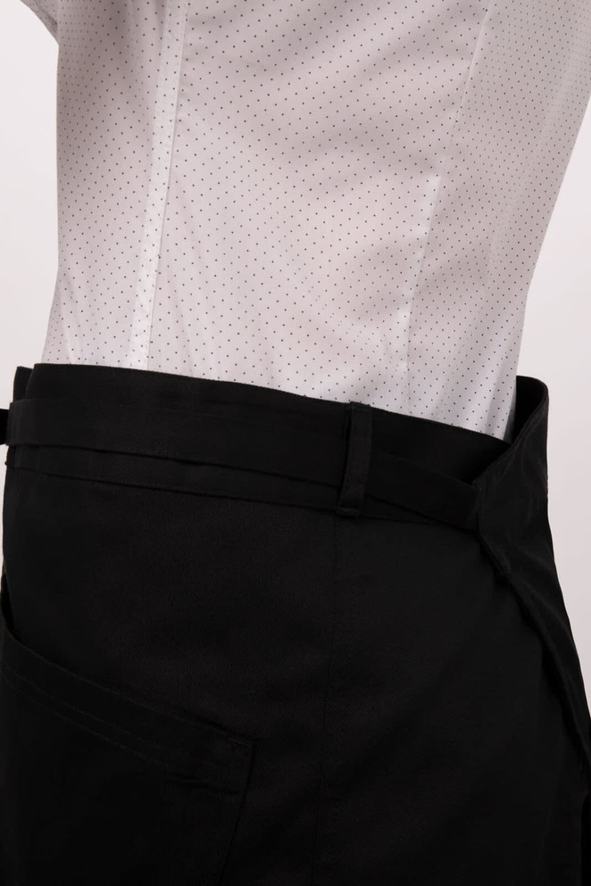 A black half bistro apron with a side pocket, worn over a white shirt with small dots.