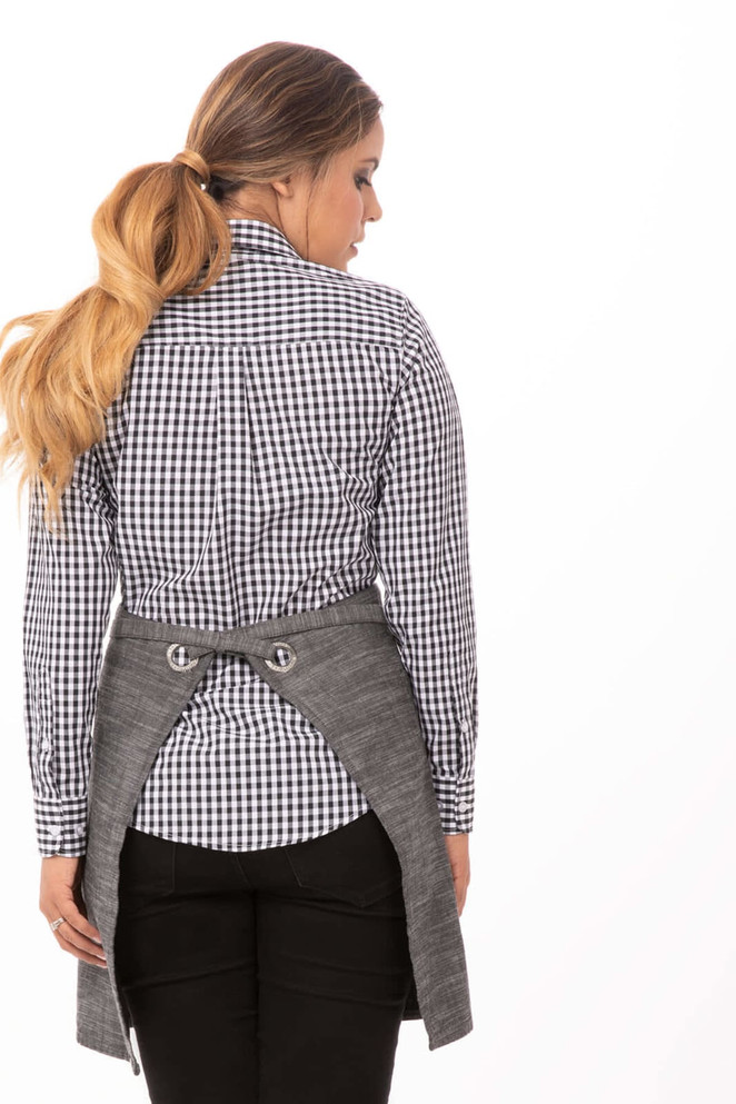 A bistro apron in grey with back ties, worn over a black and white checked shirt.