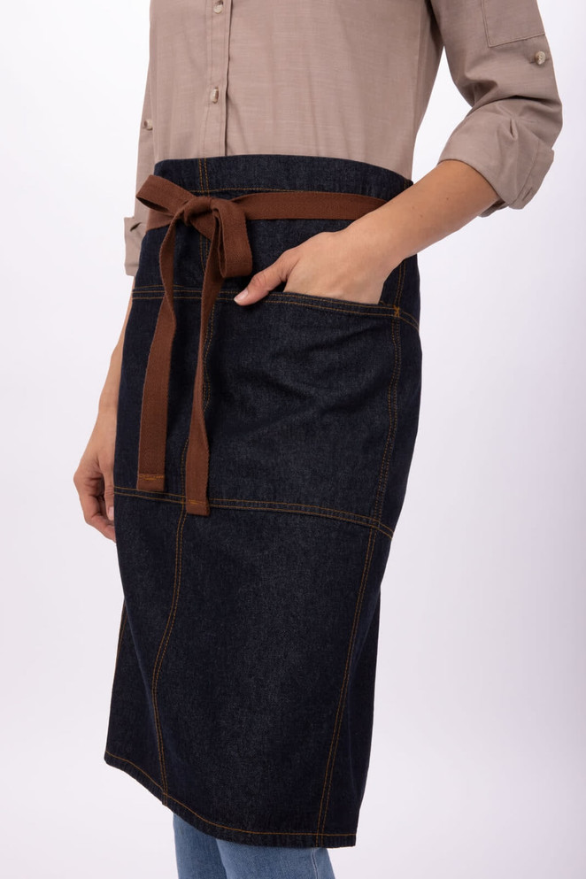 A denim bistro apron with a brown belt and pocket, featuring a stylish design for workwear.