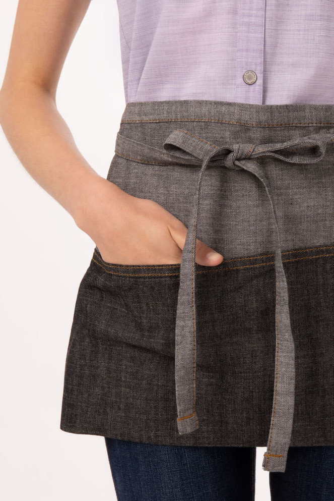 A grey waist apron with a tied belt and front pockets, made from a textured fabric.