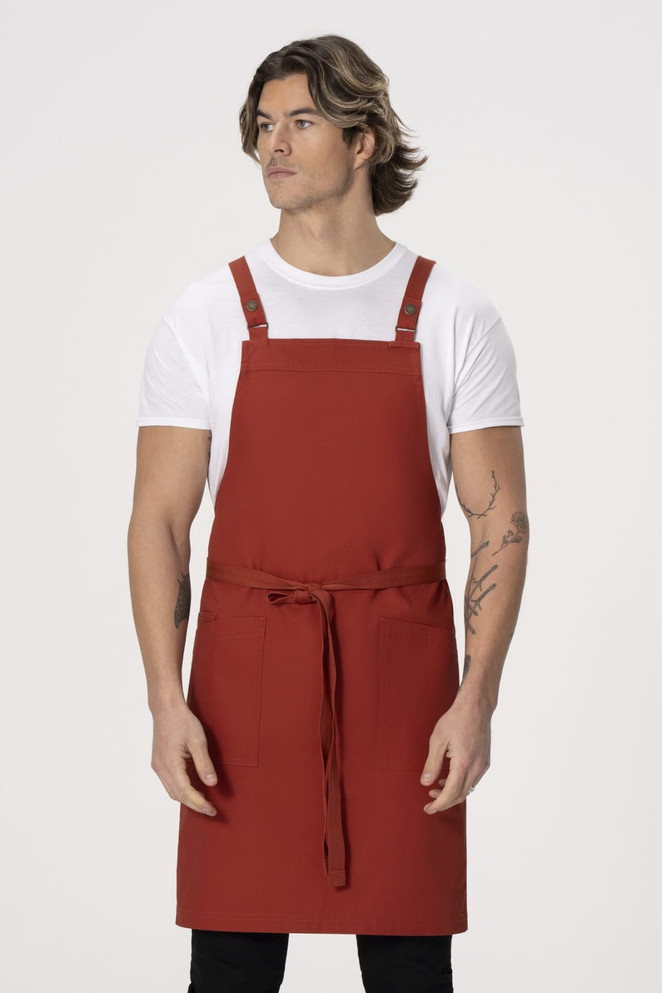 A red cross back apron is worn by a male model, with a simple design and adjustable straps.