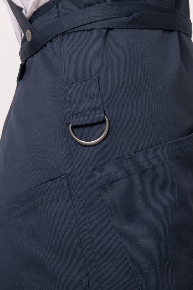 A navy blue Largo Bib Apron featuring a metal ring and pockets, designed for workwear use.