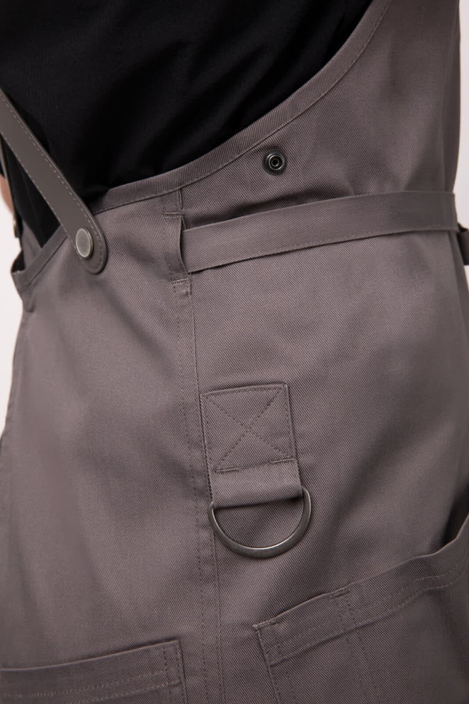 A grey Largo Bib Apron featuring a side pocket, adjustable straps, and a logo.