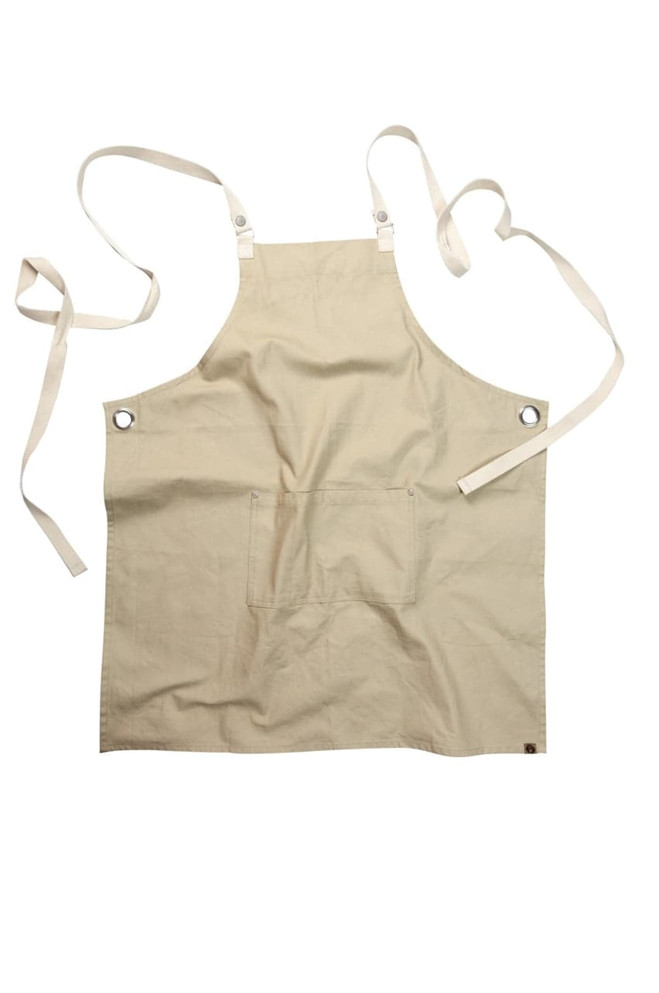A beige apron with cross-back straps, an adjustable design, and a front pocket. It features a logo.