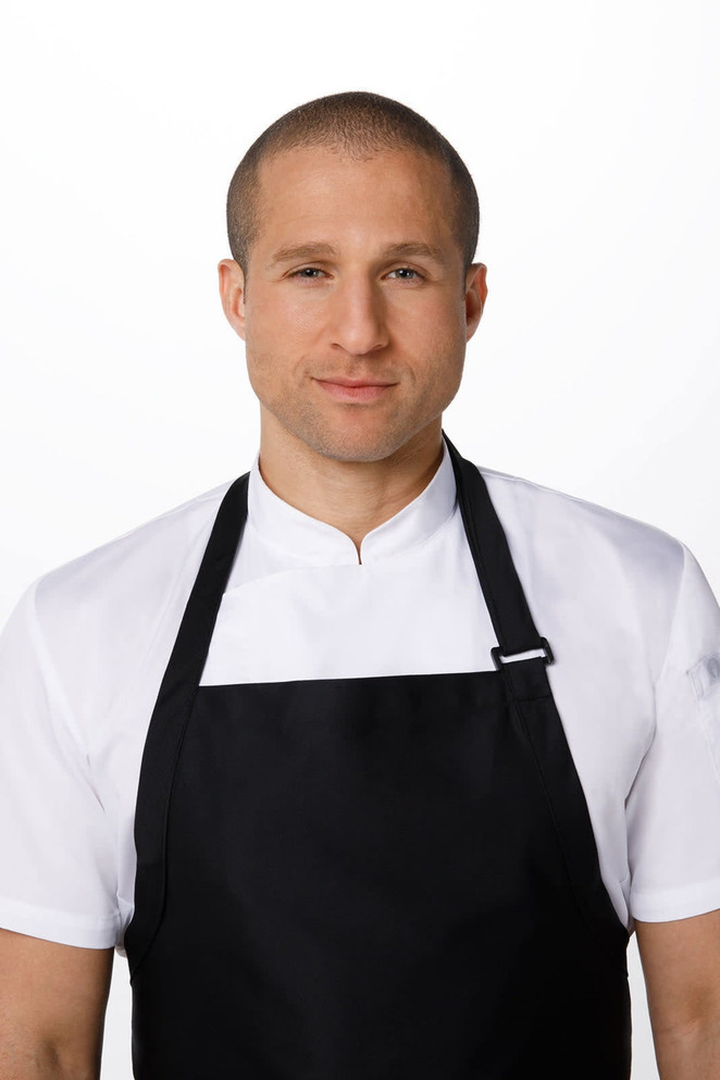 A large black bib apron worn over a white chef's shirt. The apron features a logo and is modelled by a man.