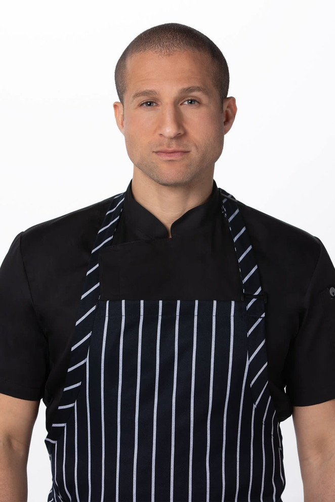 A man wearing a black shirt and a large navy and white striped bib apron with a logo.