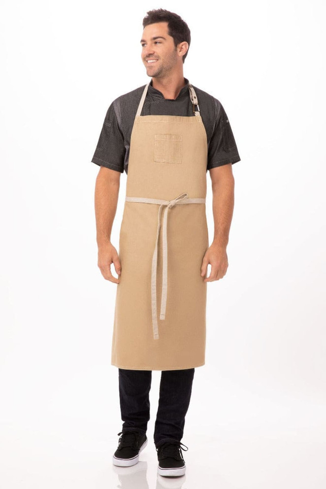 A beige bib apron with a pocket and adjustable neck strap, worn by a man standing against a white background.