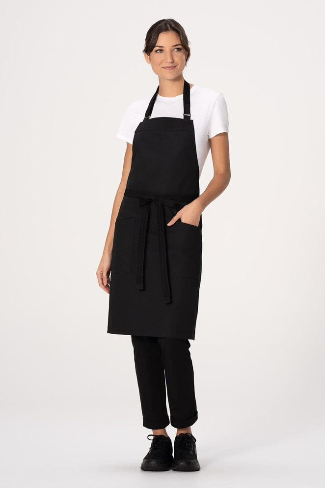 A black bib apron worn over a white t-shirt, featuring a front pocket and a waist tie.