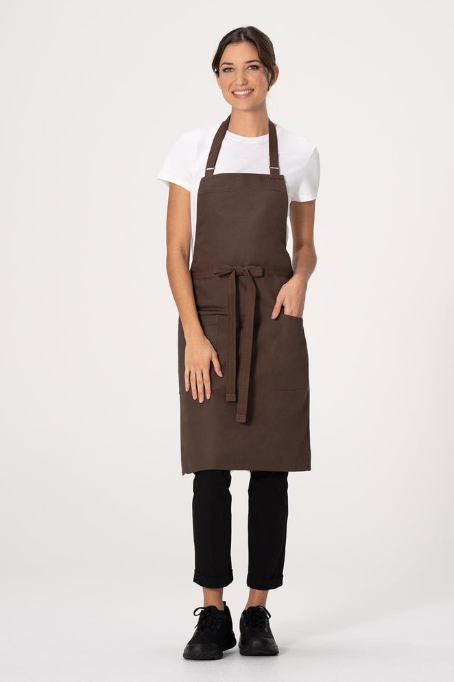 A brown bib apron with a waist tie, worn by a model in a white t-shirt and black pants, featuring a logo.