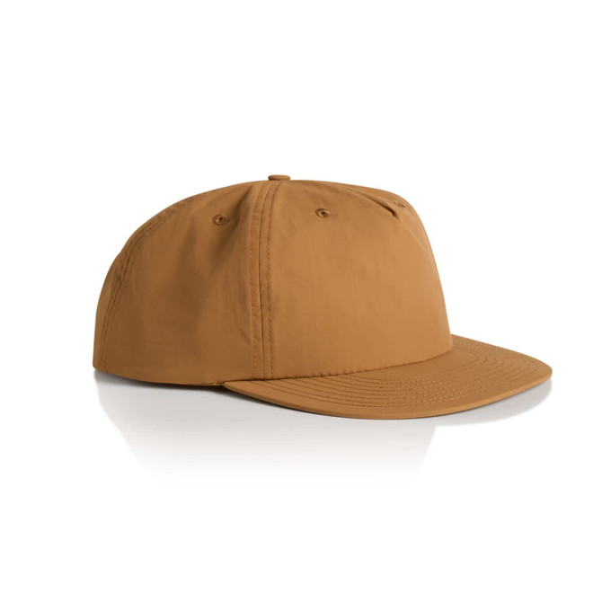 A tan surf cap with a flat brim and six-panel design, featuring a logo on the side.