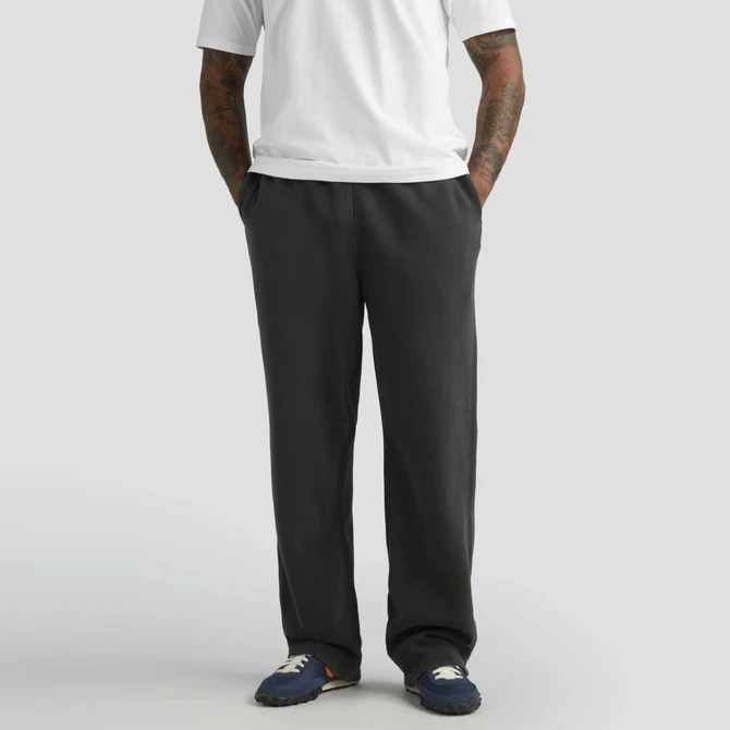 Cuffless track pants in dark grey, featuring a relaxed fit and side pockets, paired with a plain white t-shirt.