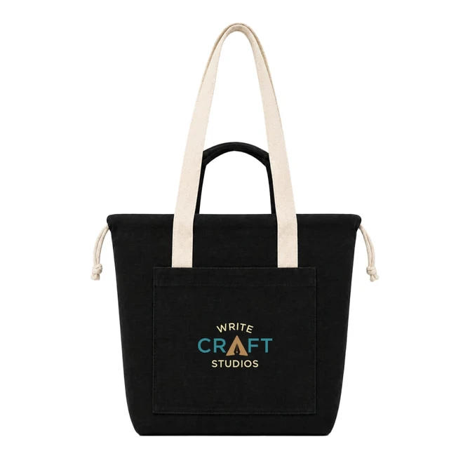 A black tote bag with long beige handles and a front pocket featuring a logo.