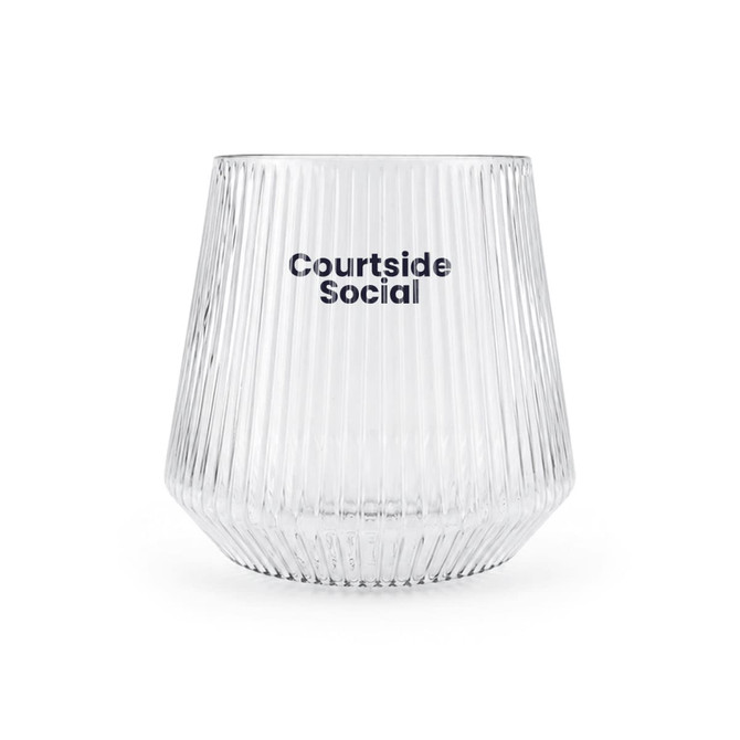 A clear, ribbed glass featuring the branding "Courtside Social." The glass has a tapered shape.